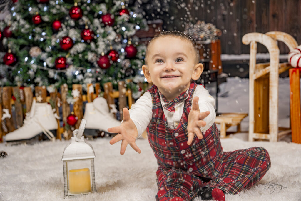 Niño disfrutando sesión navideña entre adornos y regalos en Dos Hermanas