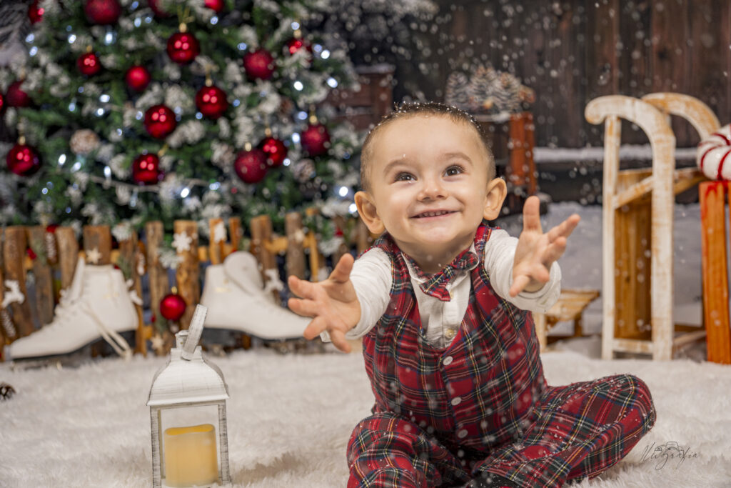 Niño jugando con nieve artificial en sesión navideña en Dos Hermanas