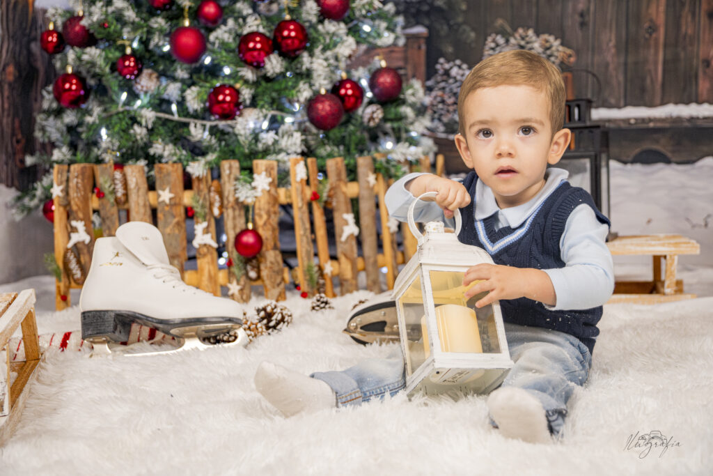 Niño sosteniendo linterna navideña en estudio de Navidad en Dos Hermanas