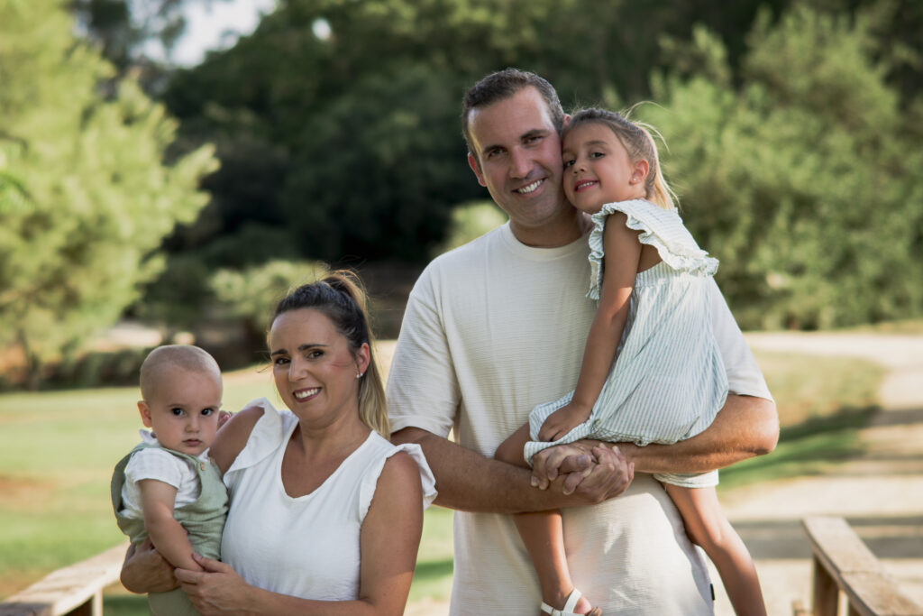 Familia abrazada durante una sesión de fotos familiar en exterior