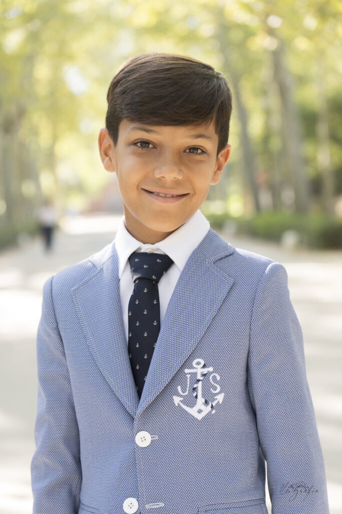 Retrato de niño de comunión sonriendo al aire libre