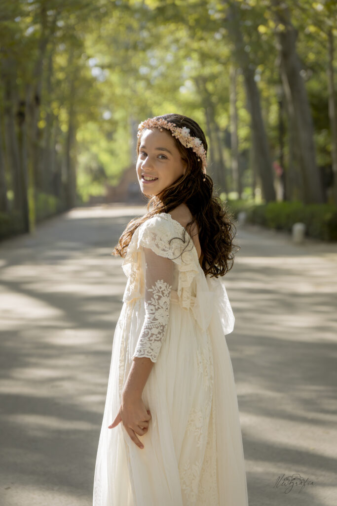 Niño de comunión con chaqueta al hombro en entorno natural