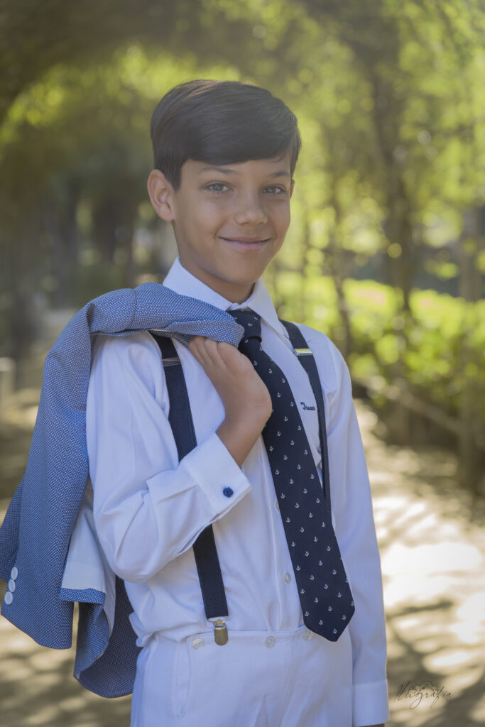 Niña de comunión caminando por un camino rodeado de árboles