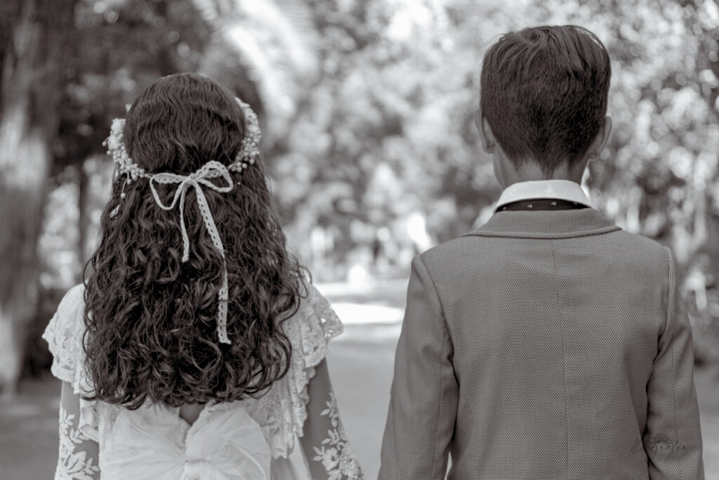 Espalda de niña y niño de comunión en blanco y negro