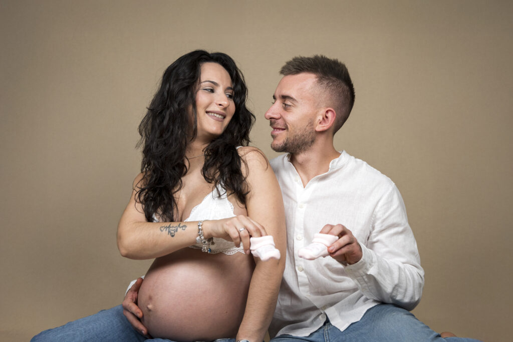 Pareja embarazada mostrando cariño en la sesión fotográfica.