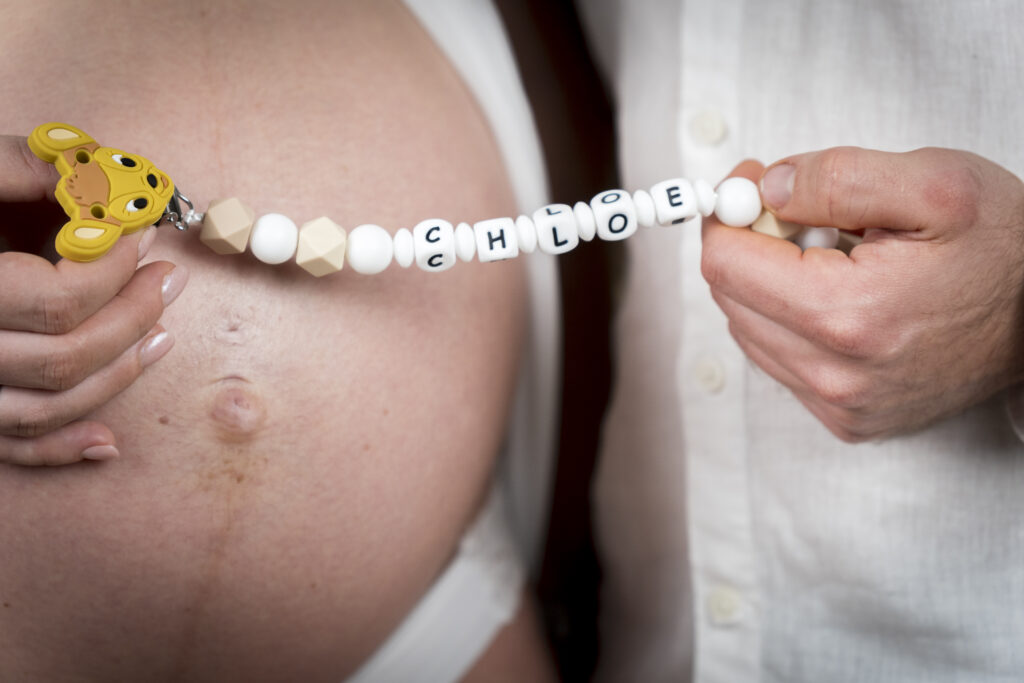 Detalle de la pancita de embarazada con collar decorativo.